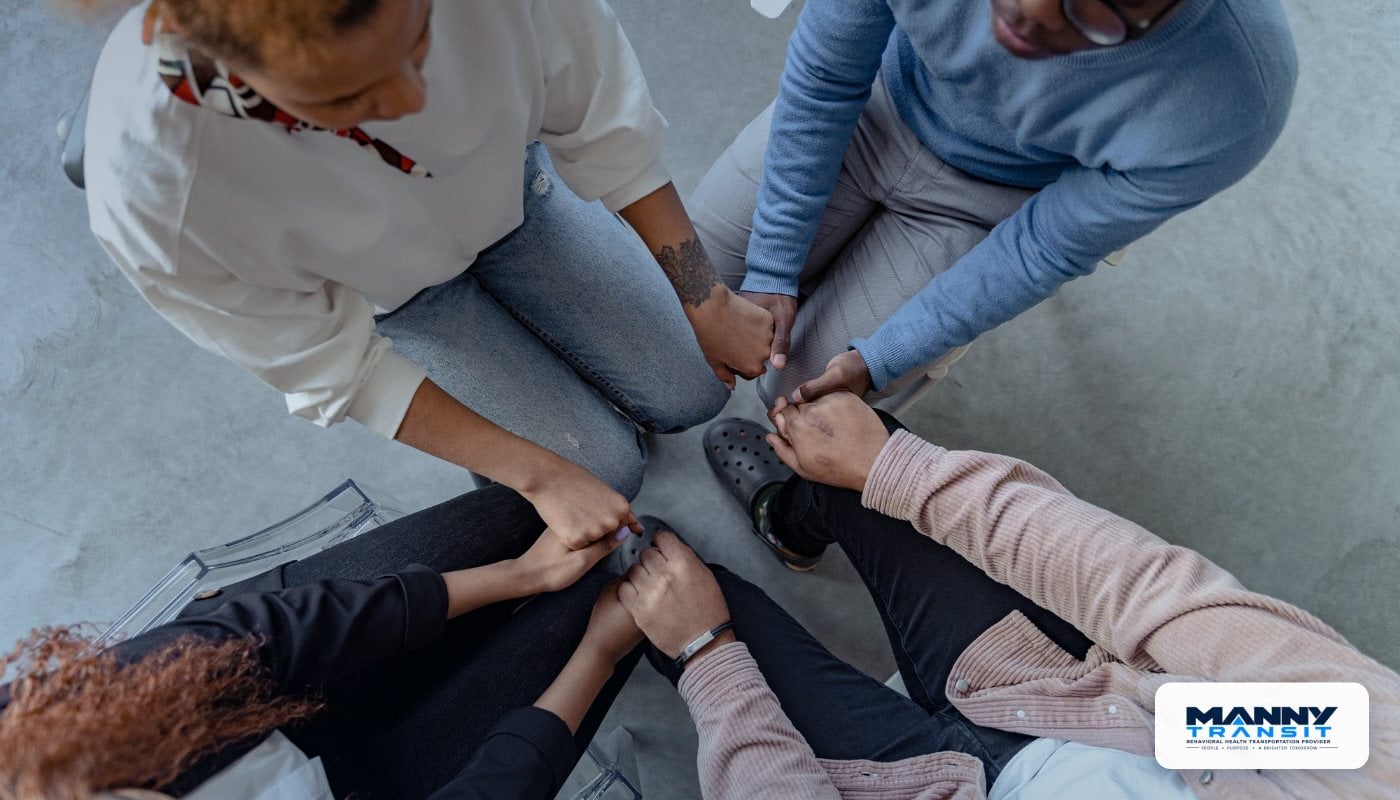 Support group holding hands in a circle at a recovery center